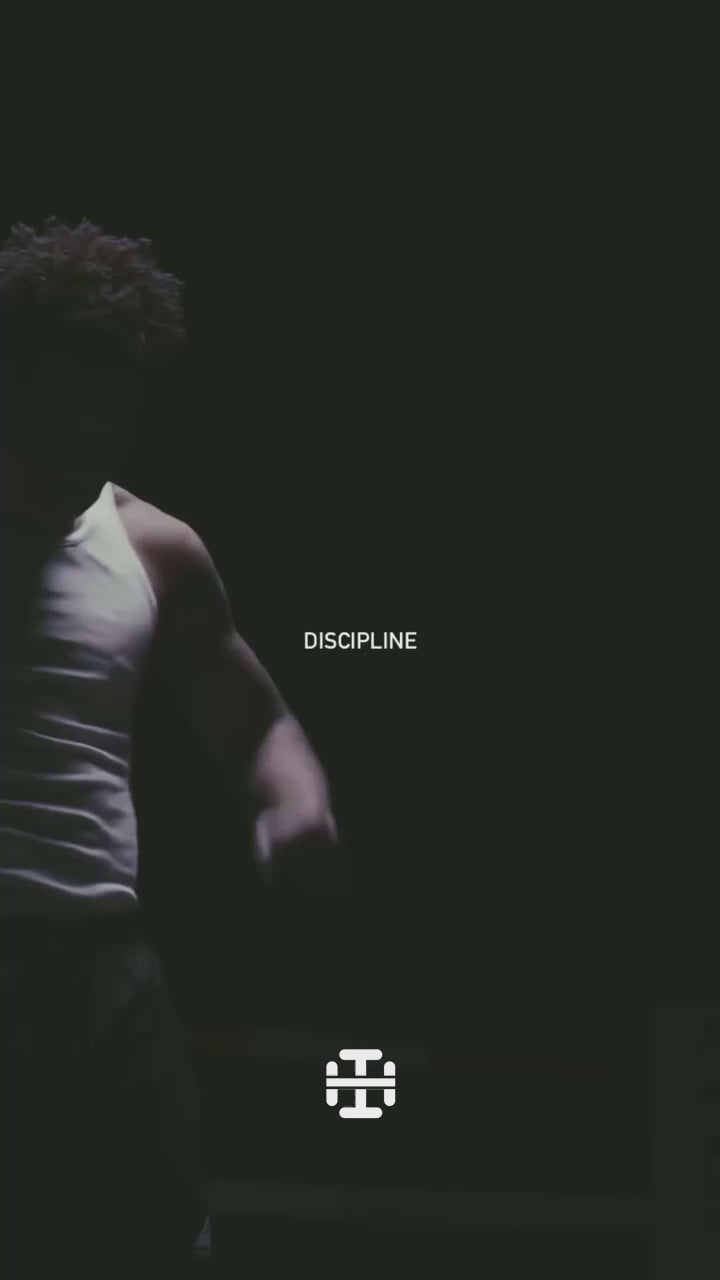 Load video: A black-and-white cinematic video of a boxer training alone in the gym. He moves with intensity—wrapping his hands, shadowboxing, and throwing heavy punches at the bag. Sweat drips, gloves strike with force, and his focus never breaks. A narrator’s voice declares: “Discipline + Focus + Action = Success.” The video closes on the Bushido Brawn logo, reinforcing the warrior ethos of strength, honor, and discipline.